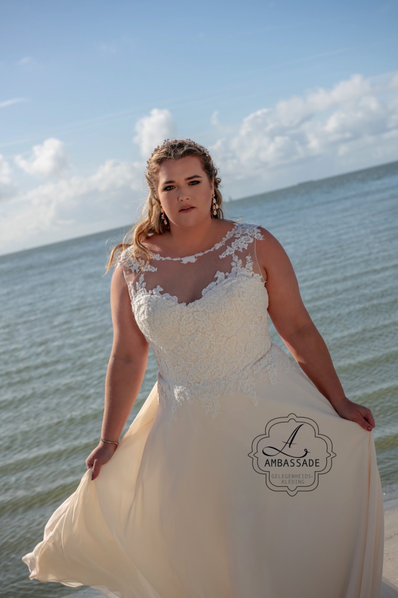 Bruid in bruidsjurk in grote maat op strand