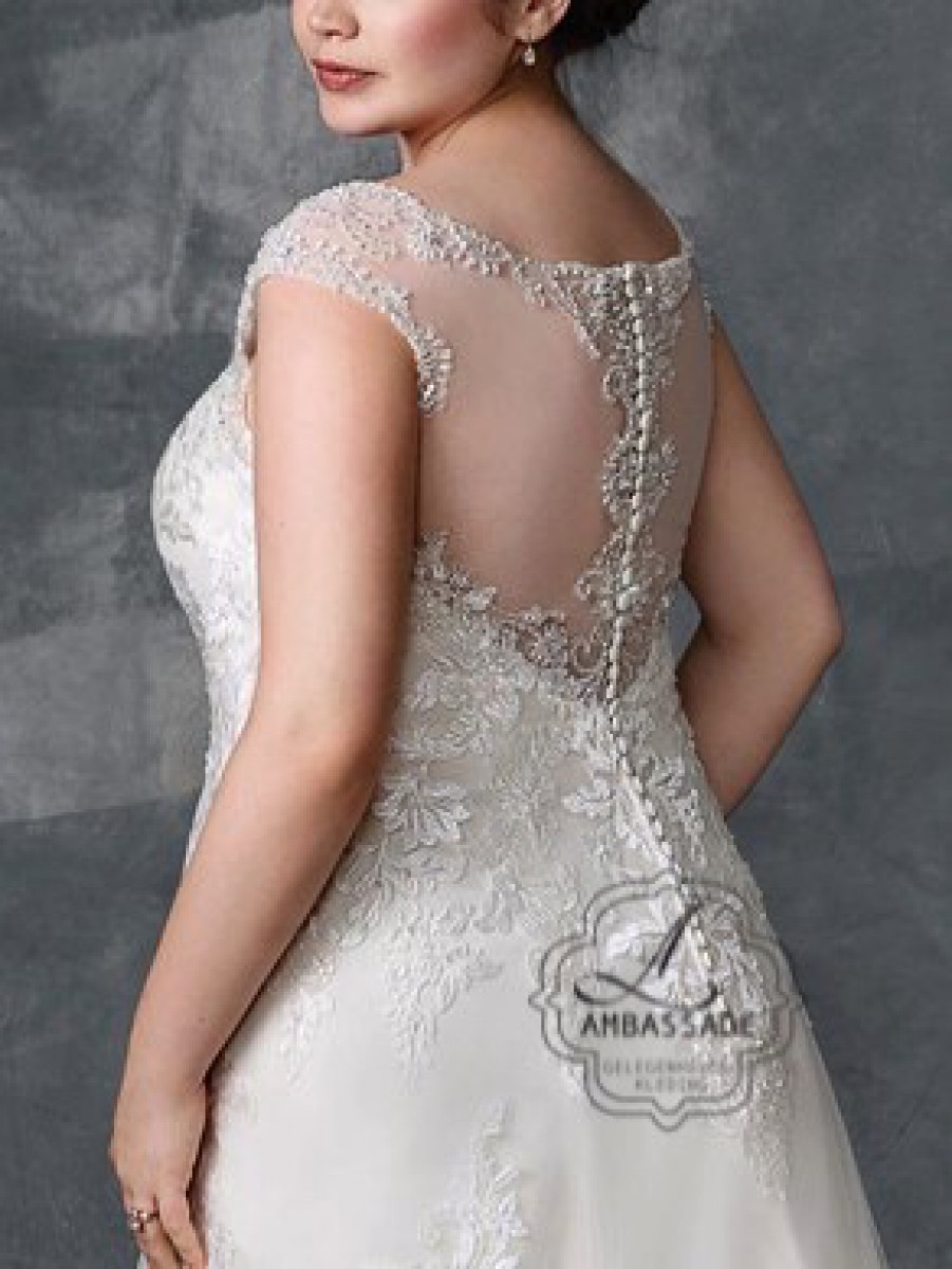 Detail van achterkant van bruidsjurk met transparante, lage rug die sluit met knoopjes.